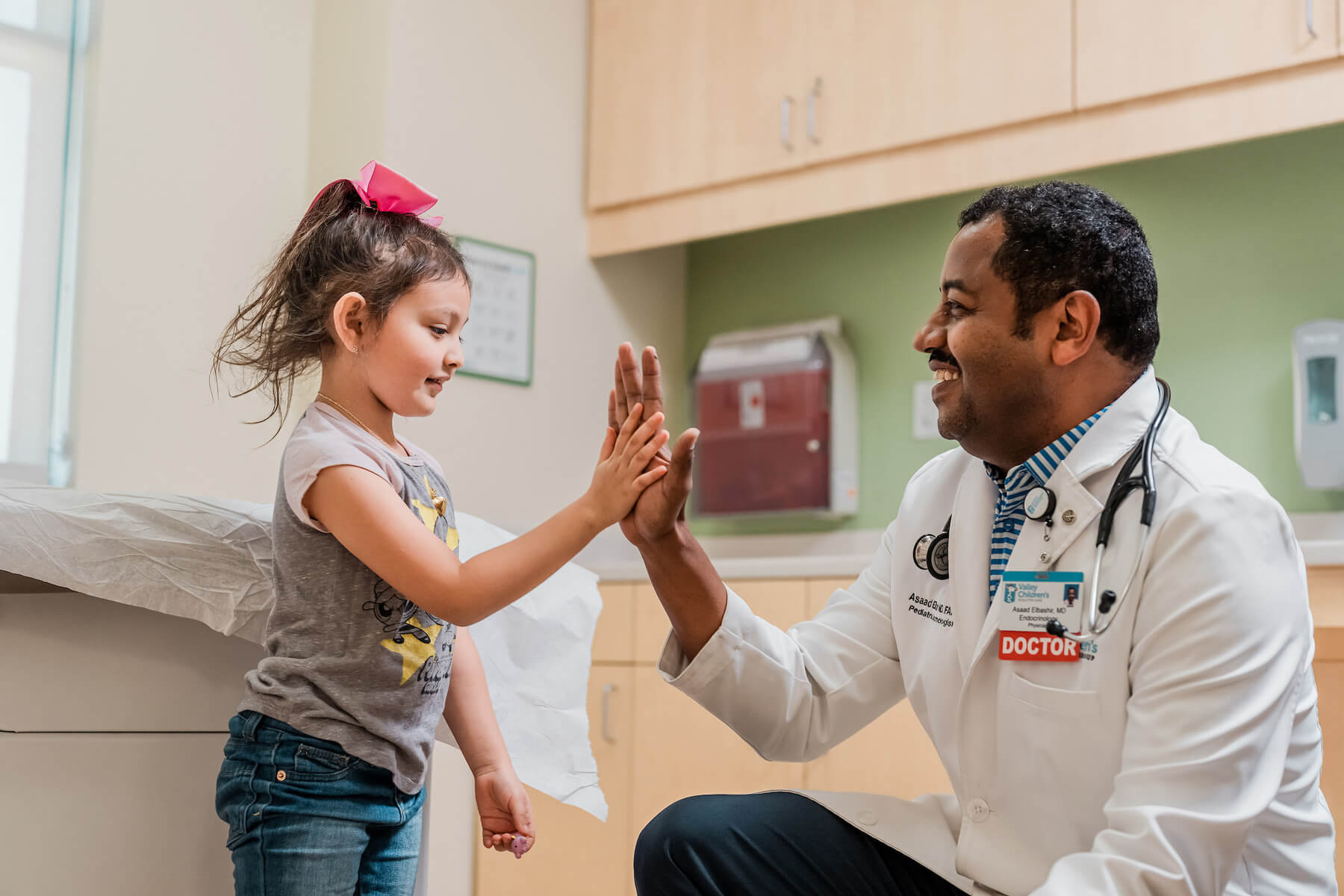 Physician giving little girl a high five