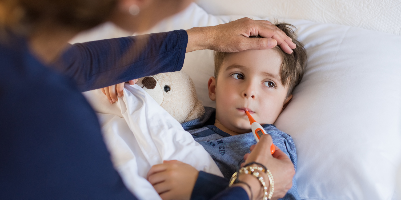 An adult feeling a child's forehead to determine their temperature