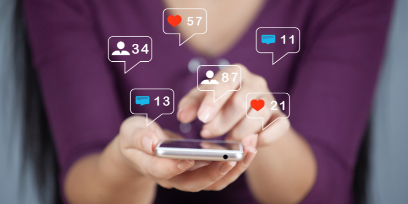 A woman on her smart phone as notifications fly out of her phone's screen