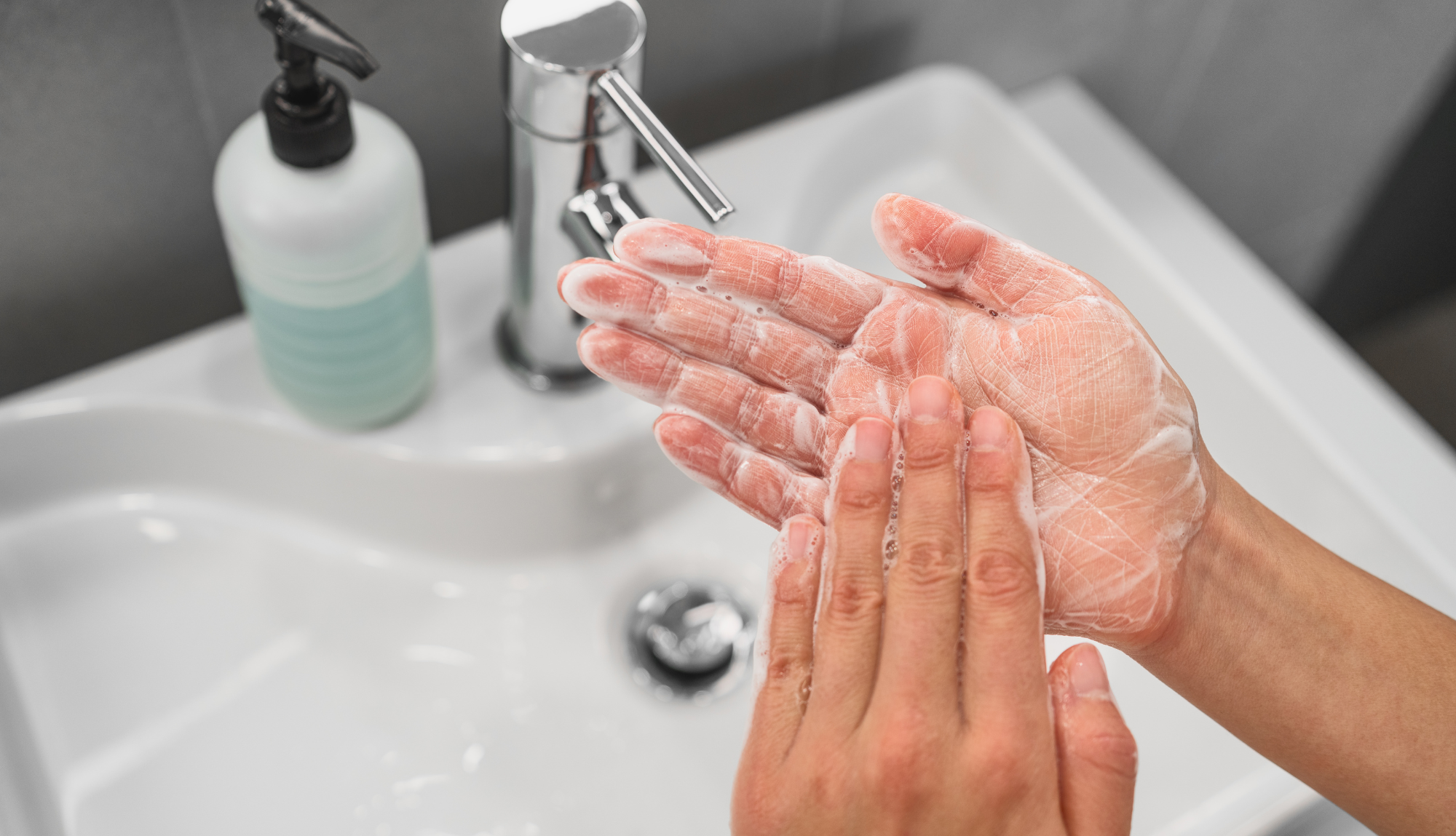 Somebody washing their hands over a sink