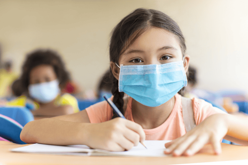 Young girl at school wearing a mask