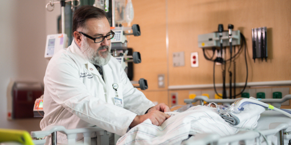 Dr. Harry Kallas attends to a patient in the PICU