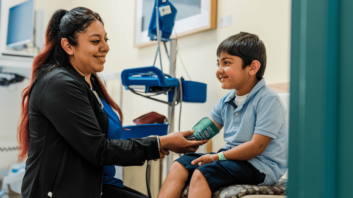 A nurse takes a young patient's vitals