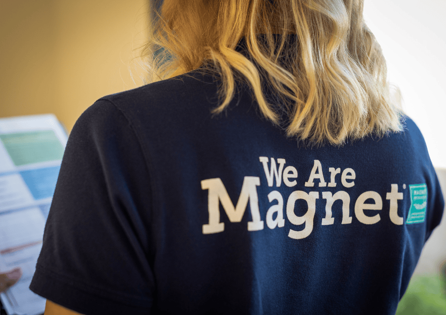 A nurse wears a shirt that says "We are Magnet"
