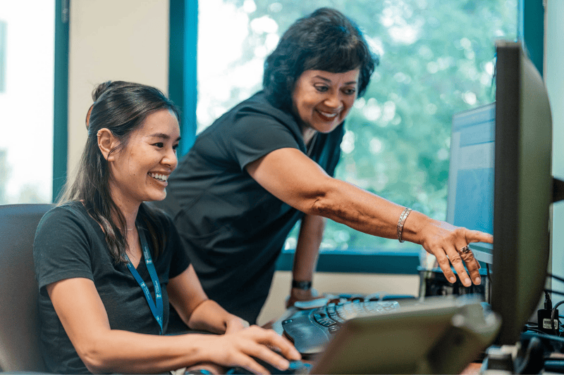 Two Valley Children's employees look at a computer screen together