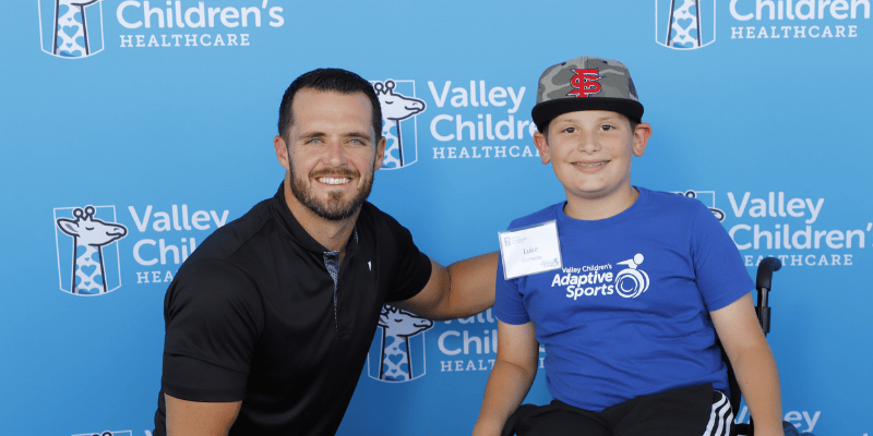 Luke smiles with Derek Carr