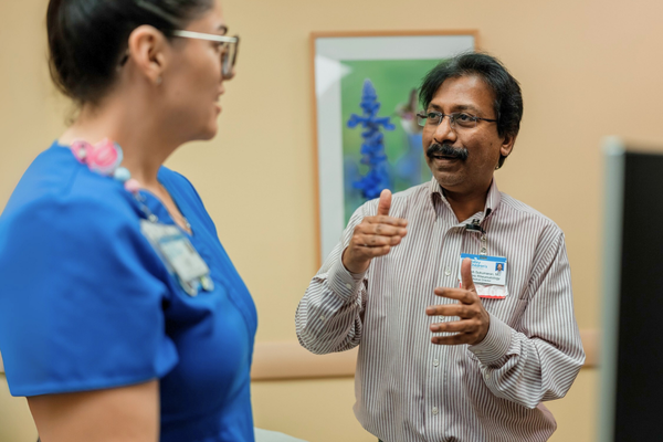 Dr. Sukesh Sukumaran speaks with a nurse in the Rheumatology clinic