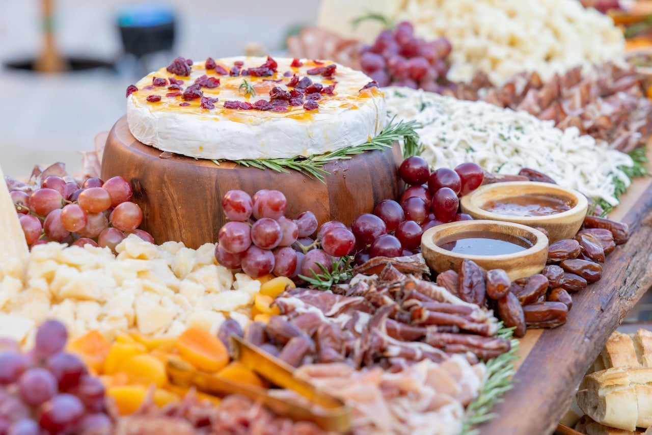 charcuterie board of meat, fruit and nuts