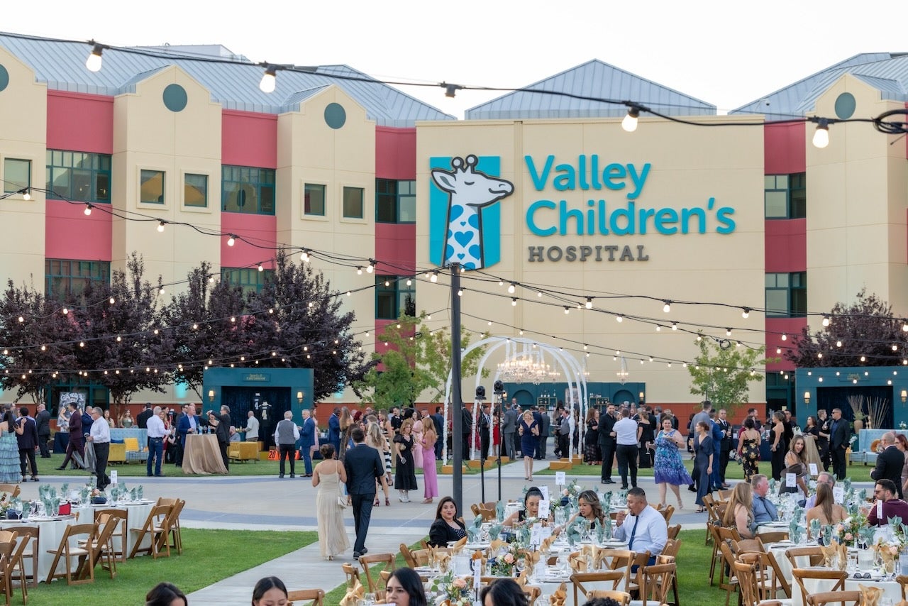 people dressed up in formal wear below the Valley Children's sign