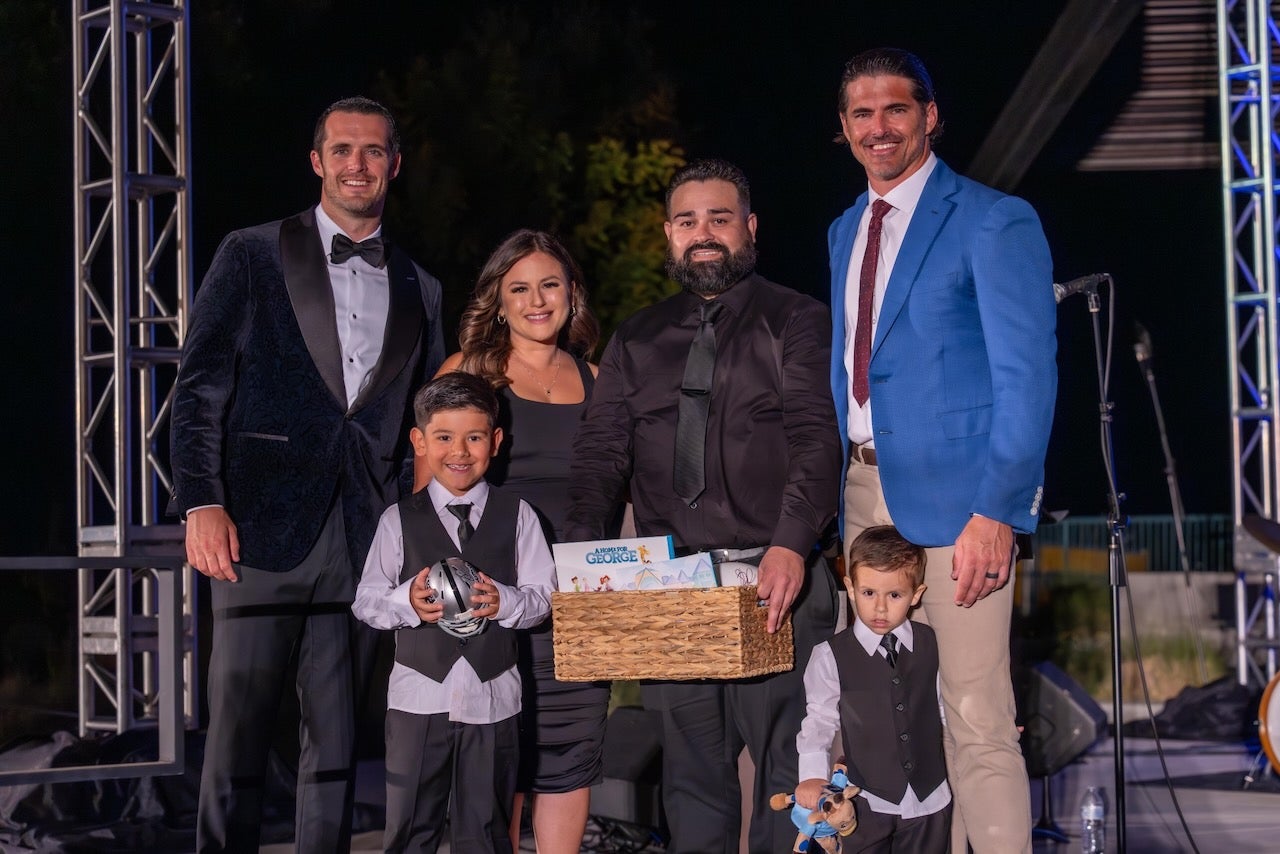 family with children pose with a group of adults