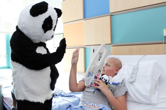 A Panda Express mascot high-fives a Valley Children's patient