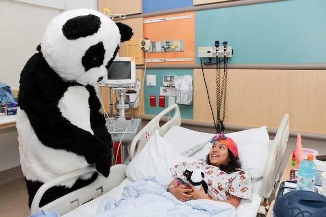 Pei Pei, Panda Express' panda mascot visits a patient in her room