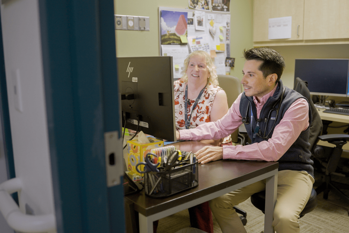 Dr. David Tomajan and Sharon VanderPlaats, NP, review information on a computer