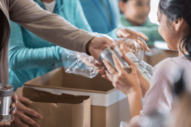 A community member receives food from a volunteer