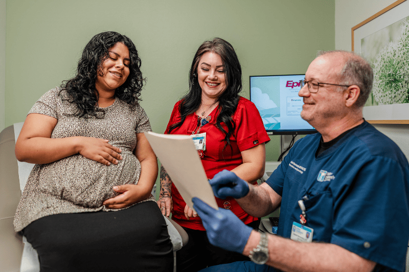 Dr. Hernandez and staff talk with a woman in clinic