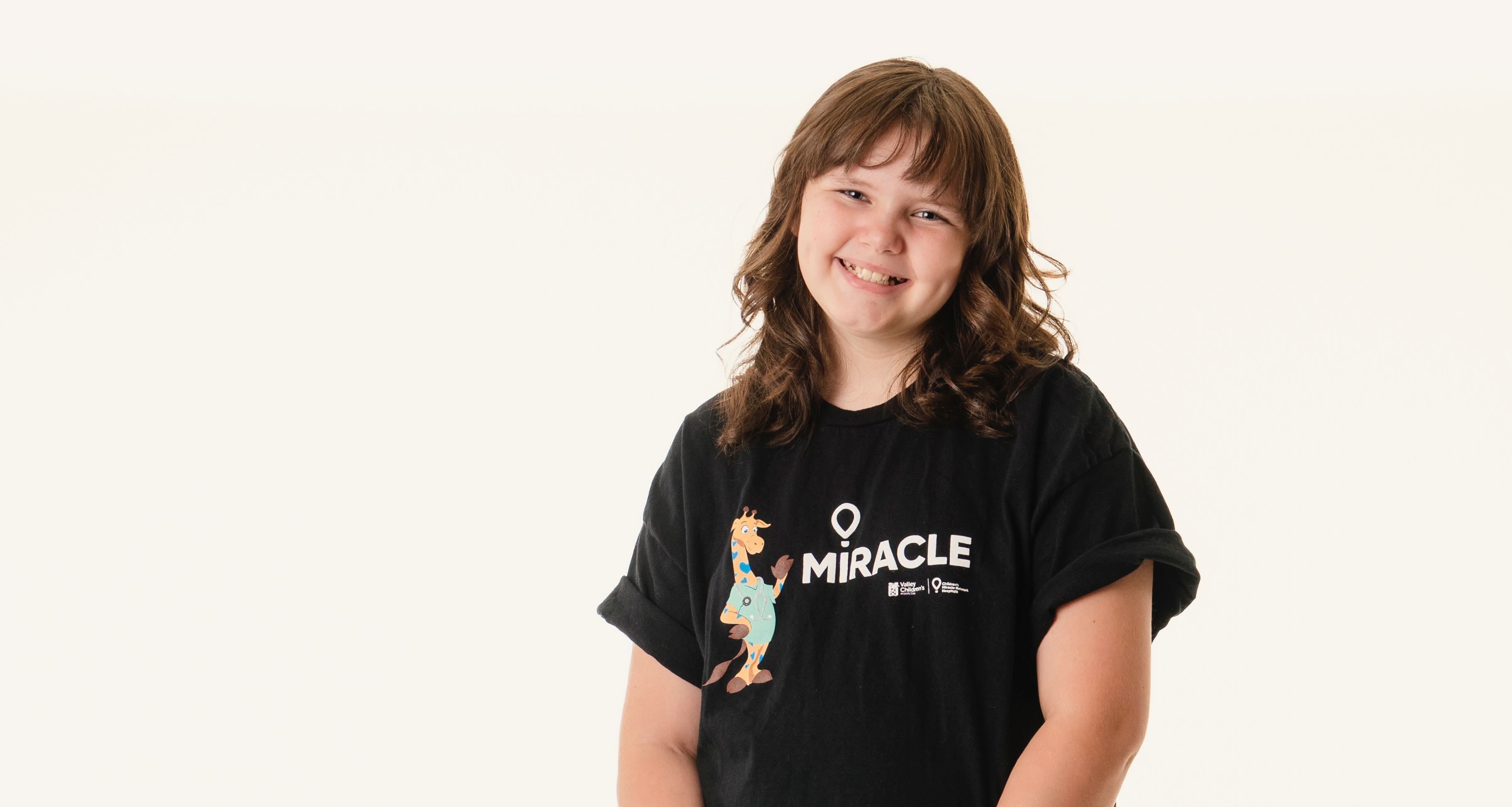 Tesla wears a Miracle shirt and smiles
