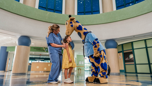 George the Giraffe standing with patient and nurse