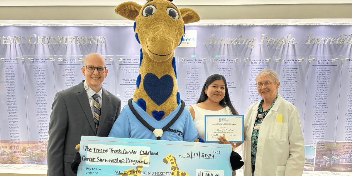 Marcy poses for a photo with Dr. John Gates, Dr. Vonda Crouse, and George the Giraffe