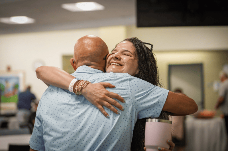 Two people hugging at a ceremony
