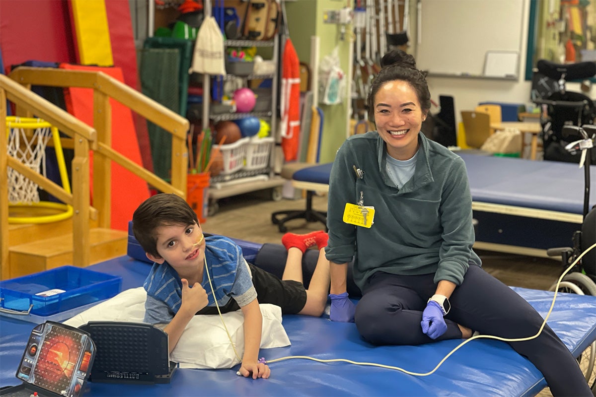 a child and rehab team member play in the gym