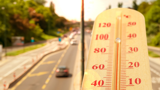 Temperature gauge by a road showing the heat