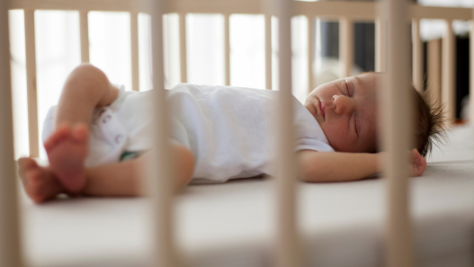 Baby practicing safe sleep in a crib