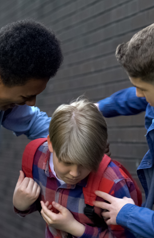 Two children pushing a younger child