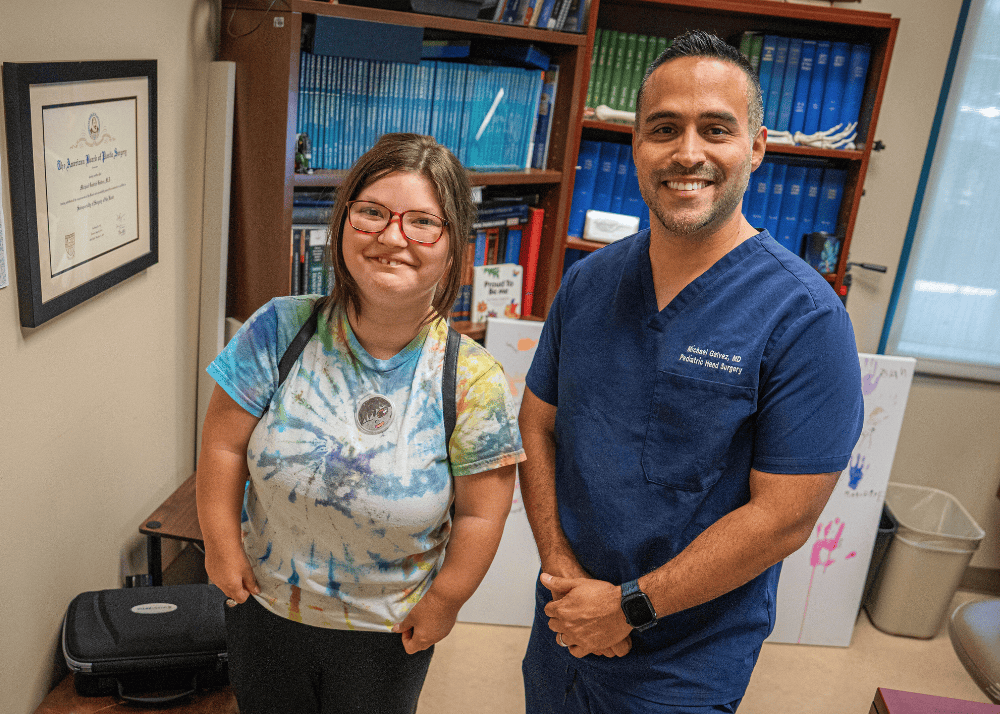 Blair and Dr. Michael Galvez smile together during a follow-up visit