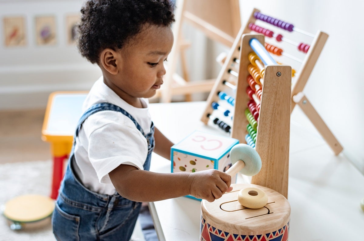 A toddler boy plays with toys