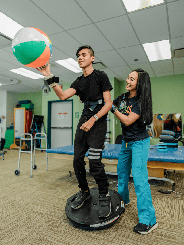A Valley Children's physical therapist works with a patient in the Rehab gym