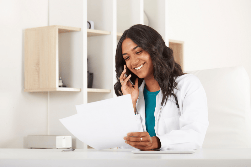 A physician smiles as she talks on the phone
